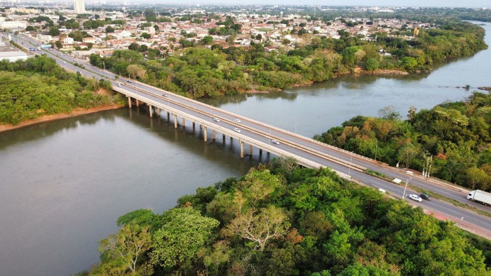 Vista aérea de uma ponte sobre um rio, cercada por vegetação, em Mato Grosso.