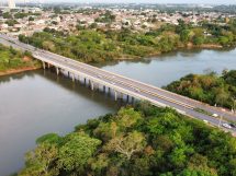 Vista aérea de uma ponte sobre um rio cercado por vegetação em Cuiabá, Mato Grosso.
