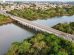 Vista aérea de uma ponte sobre um rio cercado por vegetação em Cuiabá, Mato Grosso.
