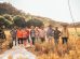 Grupo diverso de agricultores reunido em um campo iluminado pelo sol.